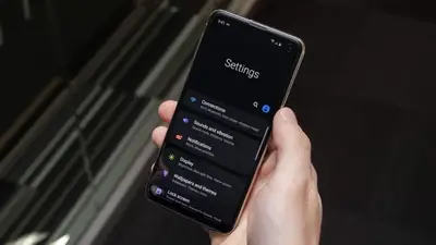 Hand holding a smartphone open on Settings