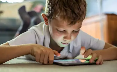 Child using a tablet with parental guidance